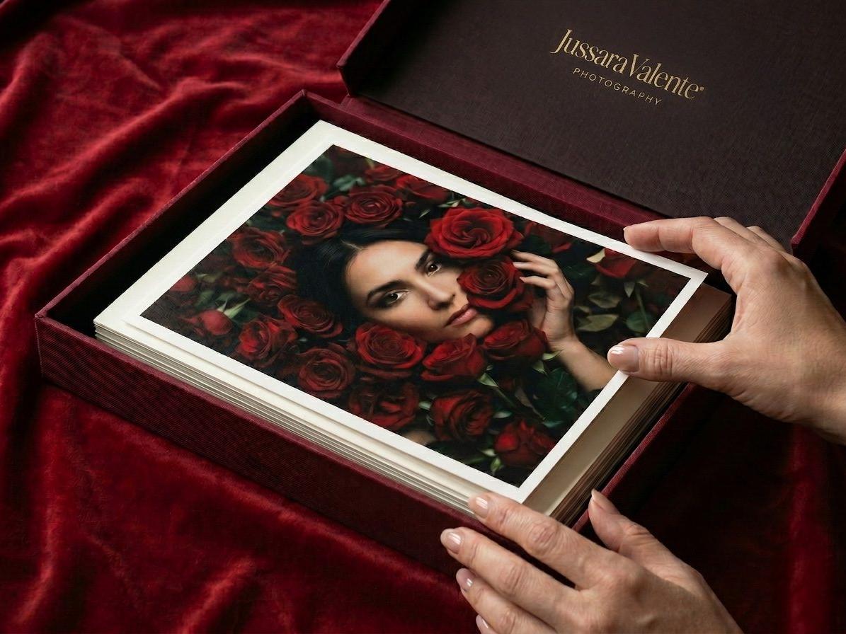 Mãos a tirar uma fotografia impressa de uma caixa com o logótipo a dourado