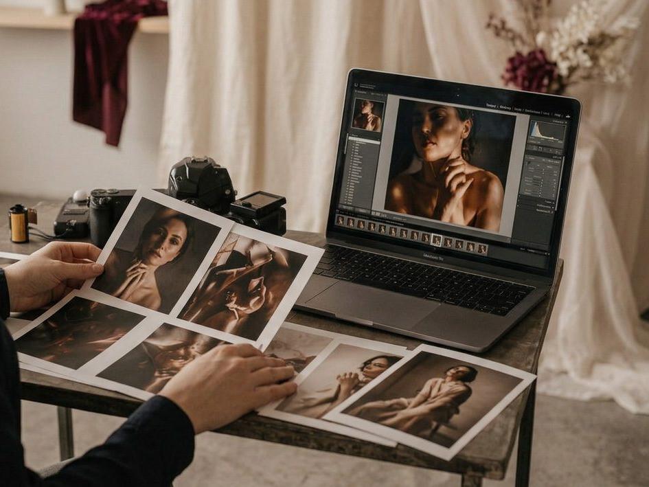 Provas fotográficas em papel ao lado de um portátil com a edição